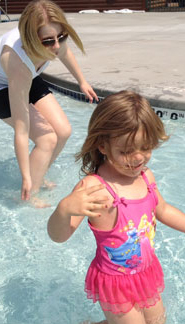 Kid and babysitter playing in the pool